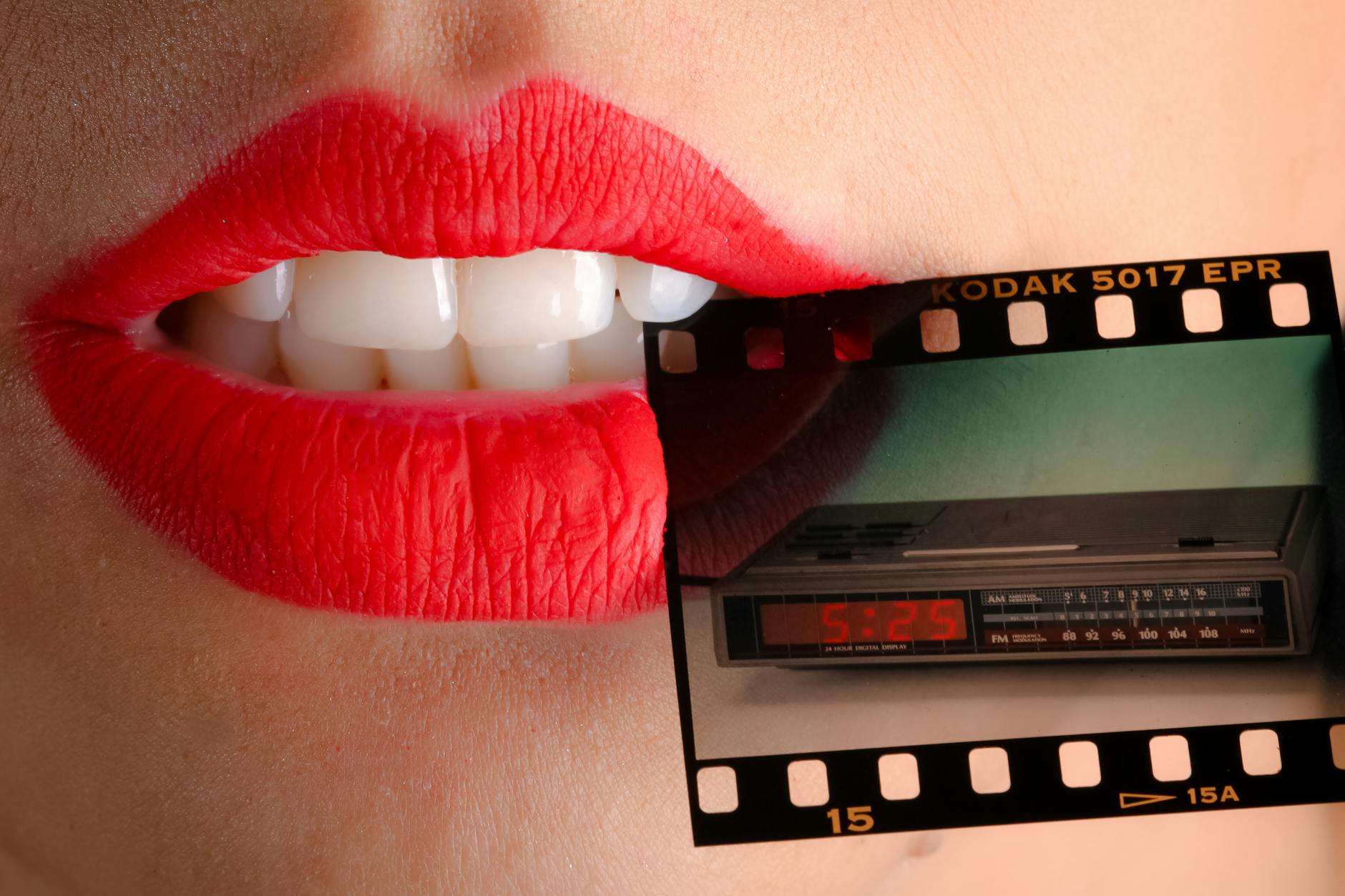 person wearing red lipstick biting film